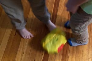 Kid's feet kicking around a bag of ice cream.