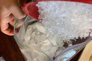 Ice and rock salt poured into a zippered bag.