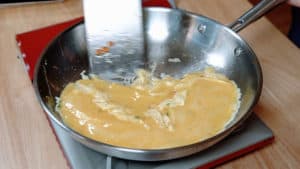 Scrambled eggs cooking in a pan.