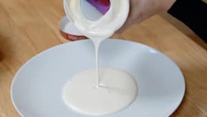 Melted vanilla ice cream poured onto a plate.