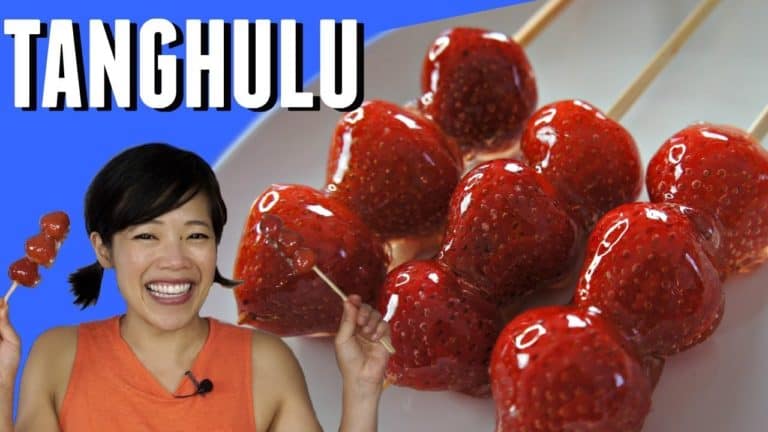 Picture of Emmy superimposed on a background that reads "TANGHULU" with three glistening skewers of red candied strawberries.