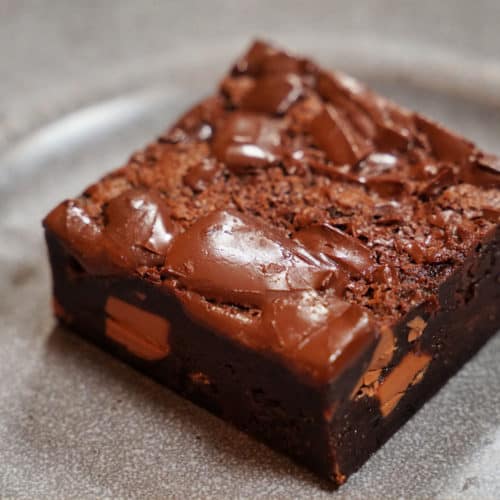 A square of brownie on a gray plate.