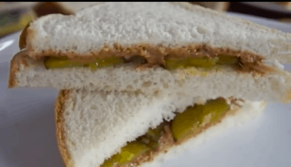 White bread sandwich cut on the bias with peanut butter and pickle filling