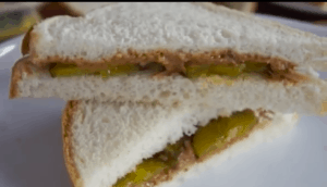 White bread sandwich cut on the bias with peanut butter and pickle filling