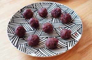 Small balls of red bean paste on a black and white geometric patterned plate.