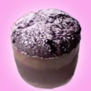 A chocolate muffin dusted with powdered sugar on a pink background.