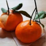 Two tangerine bao on wood countertop.