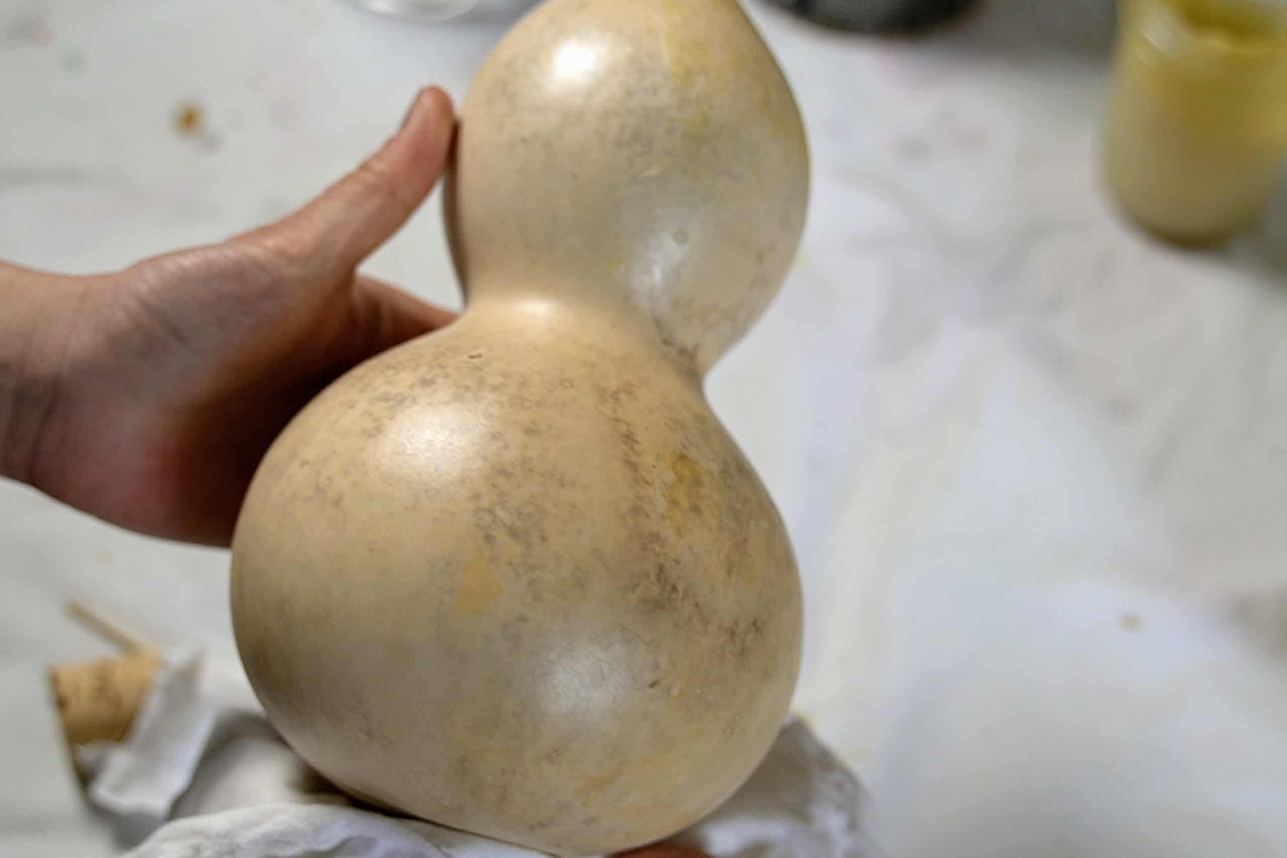 Polishing a bottle gourd with food-safe mineral oil and beeswax. 
