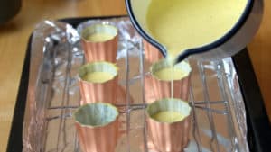 Filling canele molds with batter.