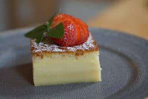 Triple layered cake with powdered sugar and strawberries on top