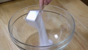 Adding sugar to mixing bowl.