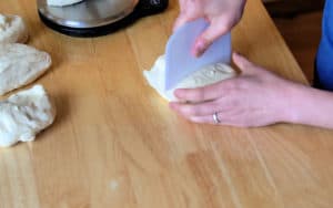 Cutting dough with bench scraper.