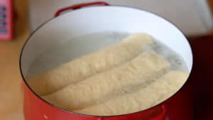 Three loaves of bread boiling in water.