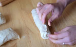 Pinching dough to seal.