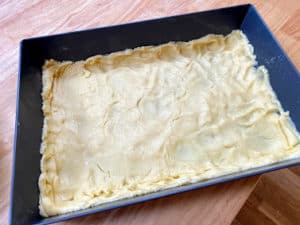 Gooey Cake prepared for the oven in brownie pan.