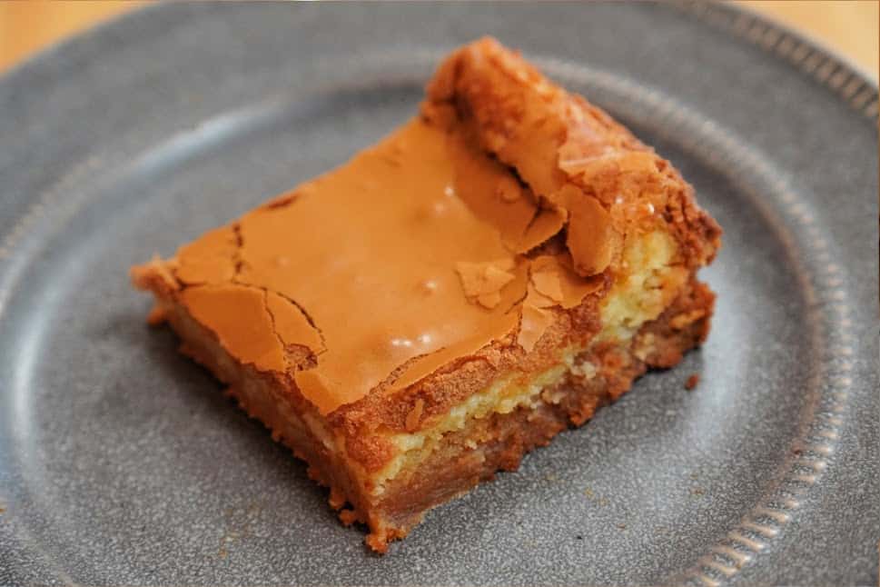 3-layered cake similar to a brownie on a grey plate.