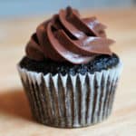 A chocolate cupcake made with greens topped with chocolate frosting.