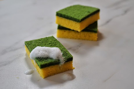 Cake that looks like dish sponges with yelllow bottom and green top with a soapy frosting.
