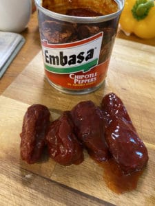 Chipotle peppers on cutting board with Embasa brand can behind.