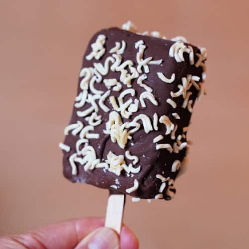 A chocolate dipped ice cream bar coated in with instant ramen.