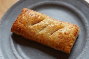 A golden brown homemade McDonald's apple pie on a grey plate.