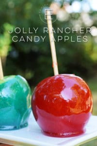 Red and blue Jolly Rancher coated apples on a white plate.