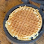 A crisp golden waffle in a waffle iron.