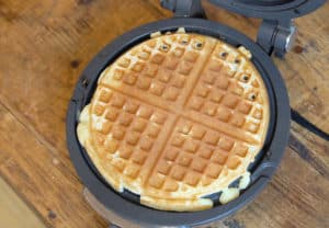 A crisp golden waffle in a waffle iron.