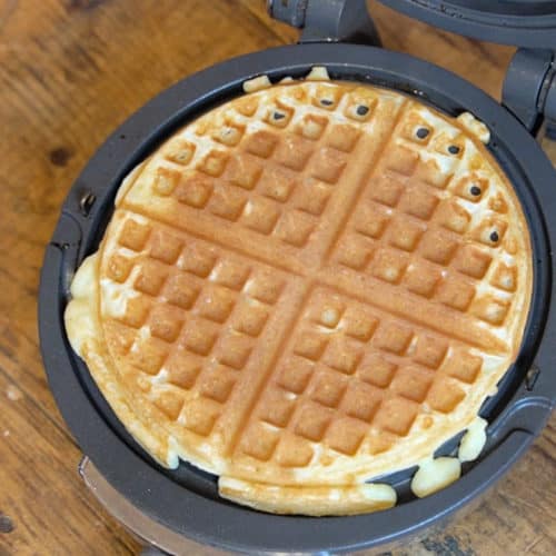 A crisp golden waffle in a waffle iron.