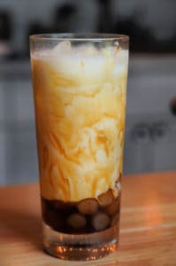 A glass of rice paper boba in brown sugar syrup and milk.