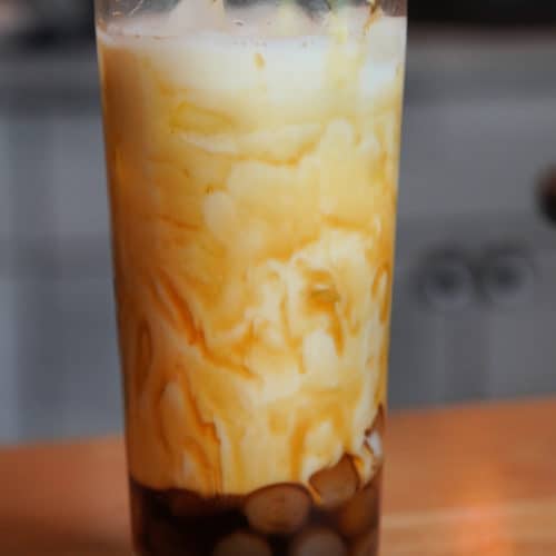 A glass of rice paper boba in brown sugar syrup and milk.