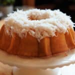 A coconut bundt cake topped with a shredded coconut glaze.