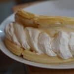 Folded waffle "taco" with cream cheese/whipped cream filling swirling out.