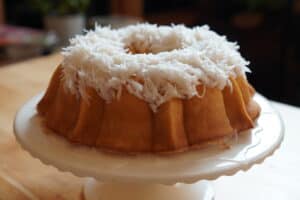 Fluted cake on cake stand with coconut icing