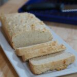 Thickly sliced homemade bread on a white serving tray.